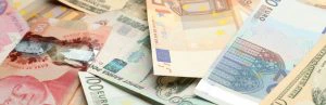 Close-up van verschillende bankbiljetten in diverse valuta, waaronder euro's en Canadese dollars, verspreid over elkaar.
