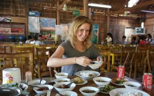 Vrouw in lokaal restaurant geniet van een maaltijd met verschillende Aziatische gerechten.