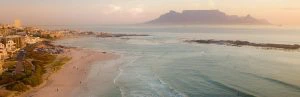 icht op Kaapstad vanaf Bloubergstrand met de Tafelberg op de achtergrond in het zachte licht van de zonsondergang.