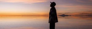 Reiziger op de zoutvlakte in Uyuni, Bolivia tijdens de zonsondergang