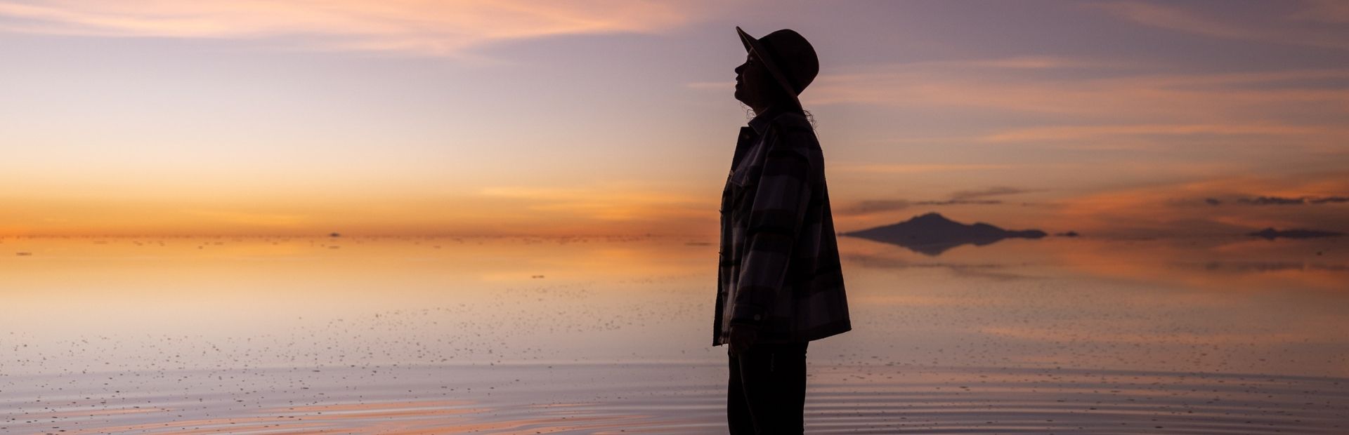 Reiziger op de zoutvlakte in Uyuni, Bolivia tijdens de zonsondergang