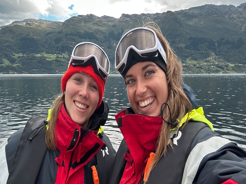 twee dames op een boot bij Hardangerfjord in Noorwegen, op de achtergrond zijn bergen te zien