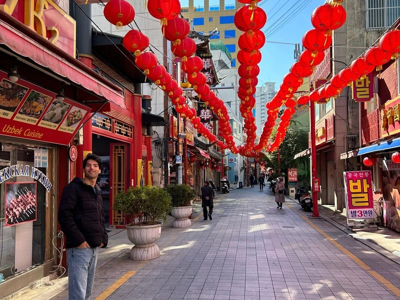 Reiziger in een straat in Busan, versierd met rode lampionnen