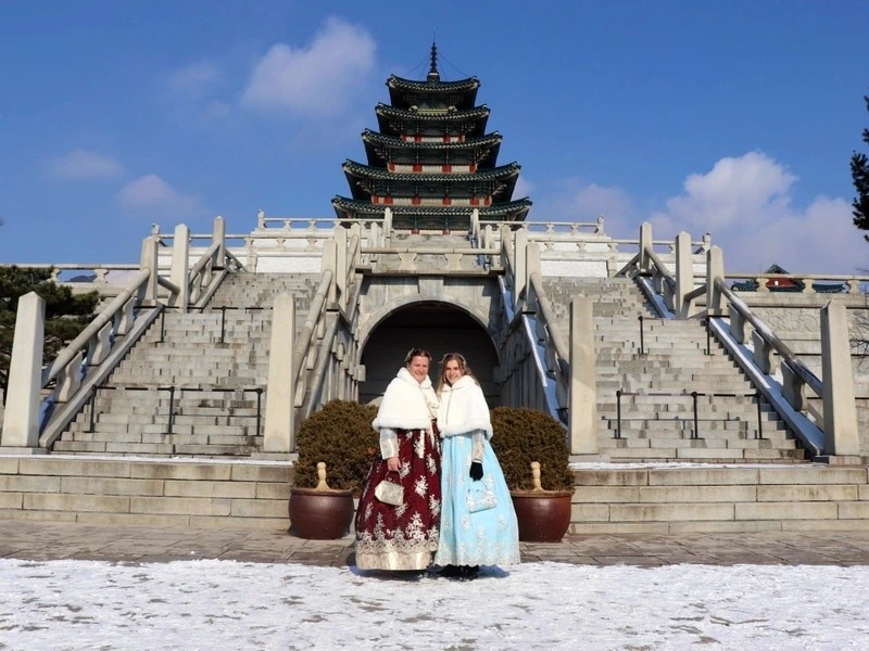 Twee reizigers bij Gyeongbokgung Palace in Seoul in traditionele kleding