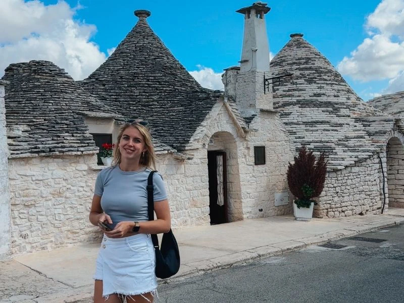Vrouw bij trulli van Alberobello in Puglia Italie