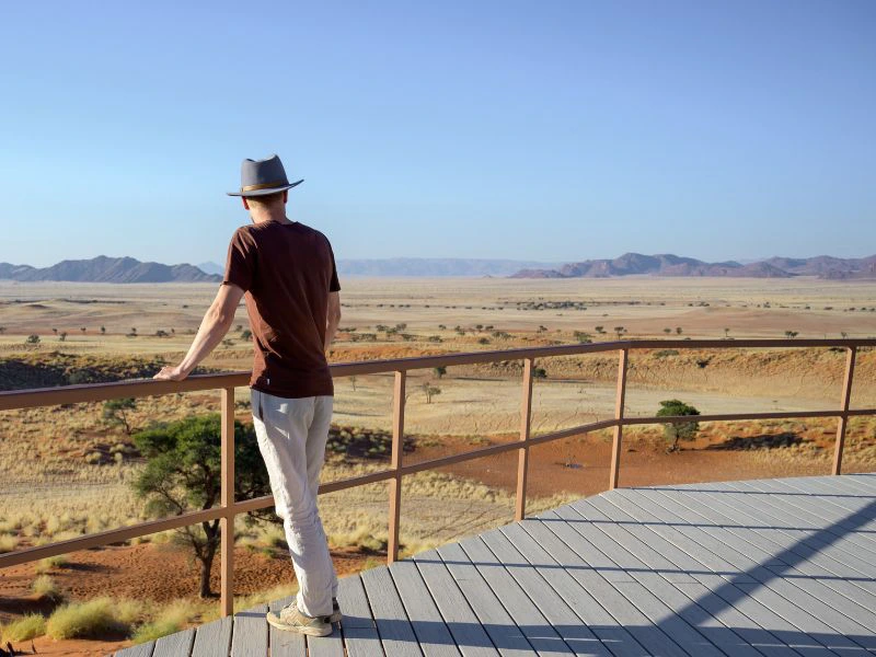 Reiziger kijkt uit over de uitgestrekte woestijn van Namibië