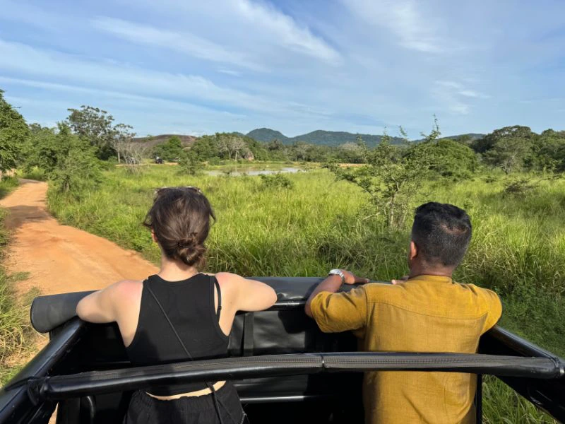 Reiziger en lokale gids kijken uit het dak van een auto.