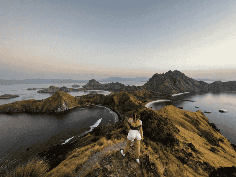 Reiziger die poseert bovenop Padar Island bij de Komodo-eilanden in Indonesië.