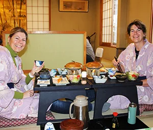 Japan Sushi eten aan een lage tafel waar twee vrouwen aanzitten.