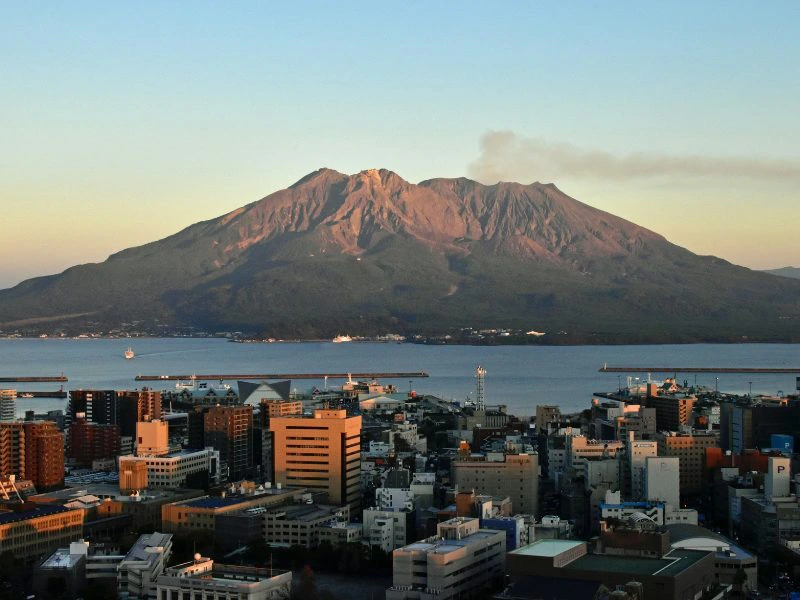 Uitzicht op de stad Kagoshima met daarachter de actieve vulkaan Sakurajima in Japan.