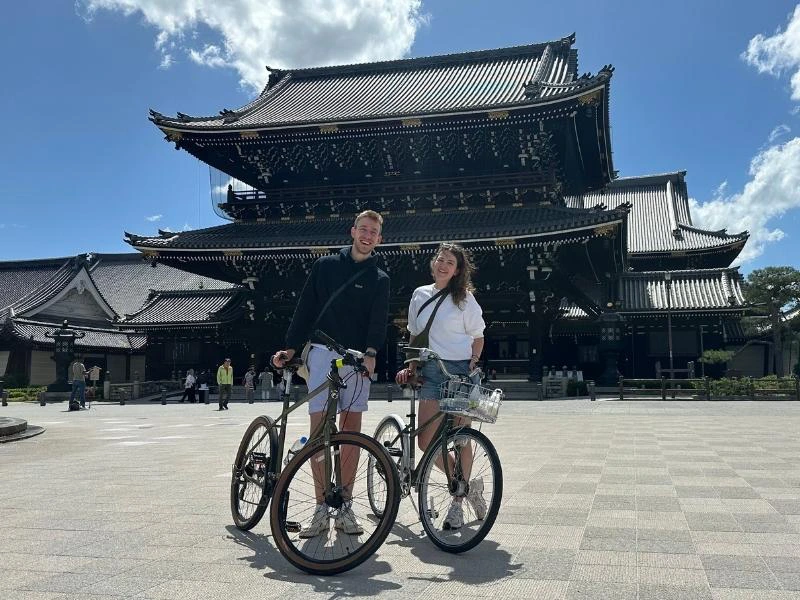 twee mensen voor een tempel in Kyoto met de fiets in de hand