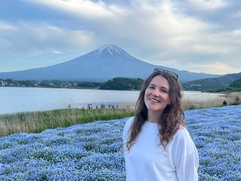 Vrouw in bloemenveld met Mount Fuji op de achtergrond