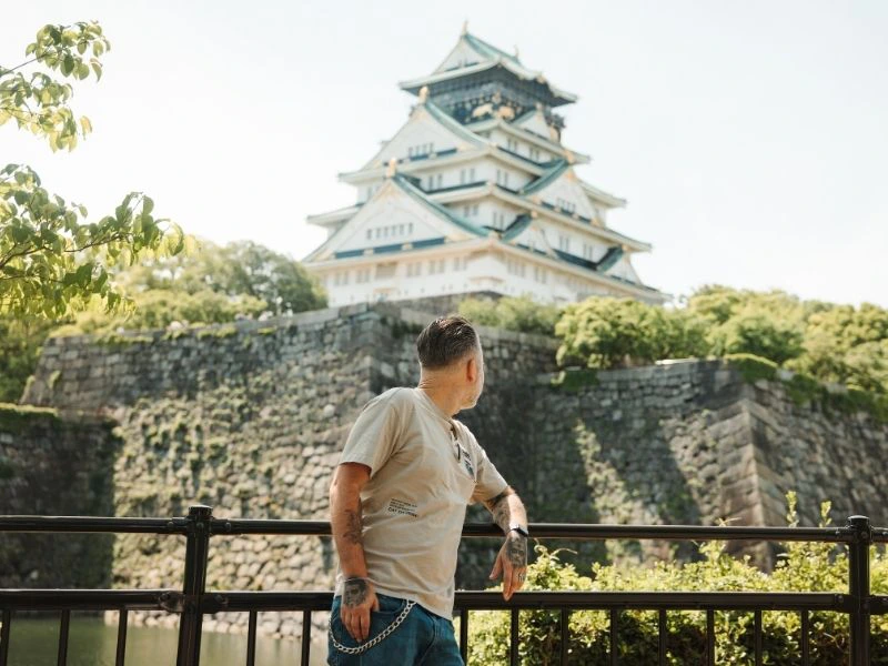 Man staat voor een tempel in Osaka en kijkt naar de tempel