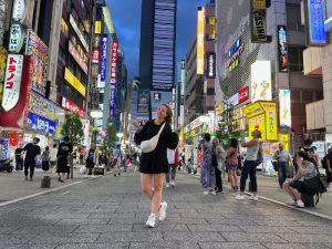 Vrouw op straat in Tokyo tussen hoge gebouwen met neon verlichting