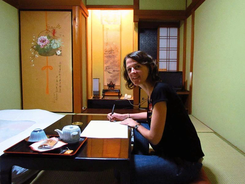 vrouw zit aan een bureau en schrijft in koyasan