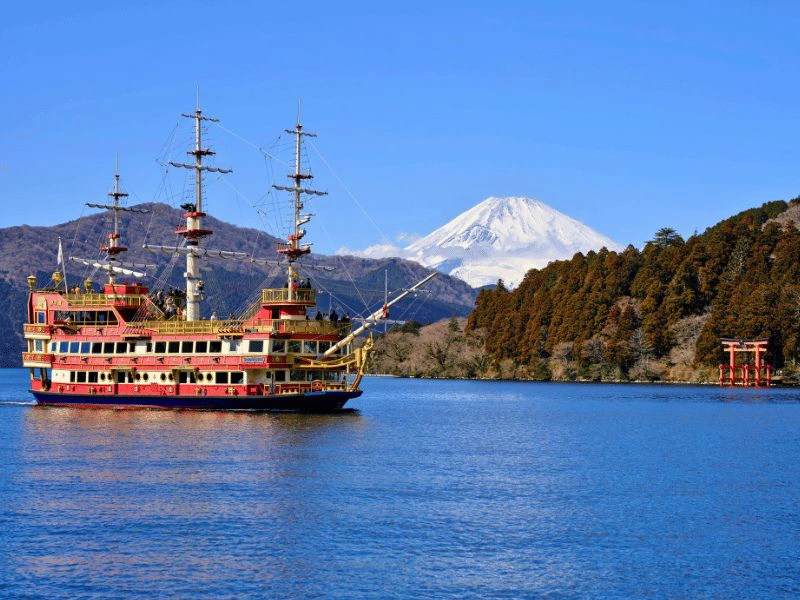 Boot vaart over meer met Mount Fuji op de achtegrond