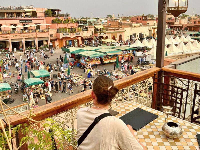 Vrouw kijkt uit over plein Marrakech