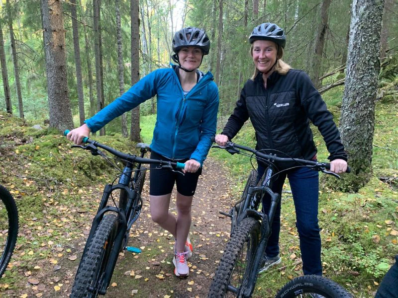 Twee vrouwen met hun mountainbike in het bos.