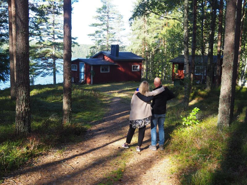 Stel in Noorwegen in het bos voor een typische rode Noorse cabin.