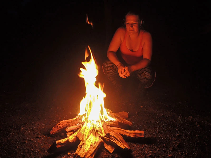 Vrouw bij een kampvuur