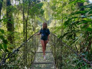 Vrouw loopt over een hangbrug in de jungle van Costa Rica