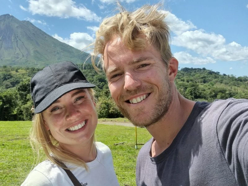 Twee lachende mensen in Costa Rica met bergen op de achtergrond