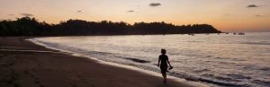 Vrouw op het strand bij zonsondergang in Costa Rica