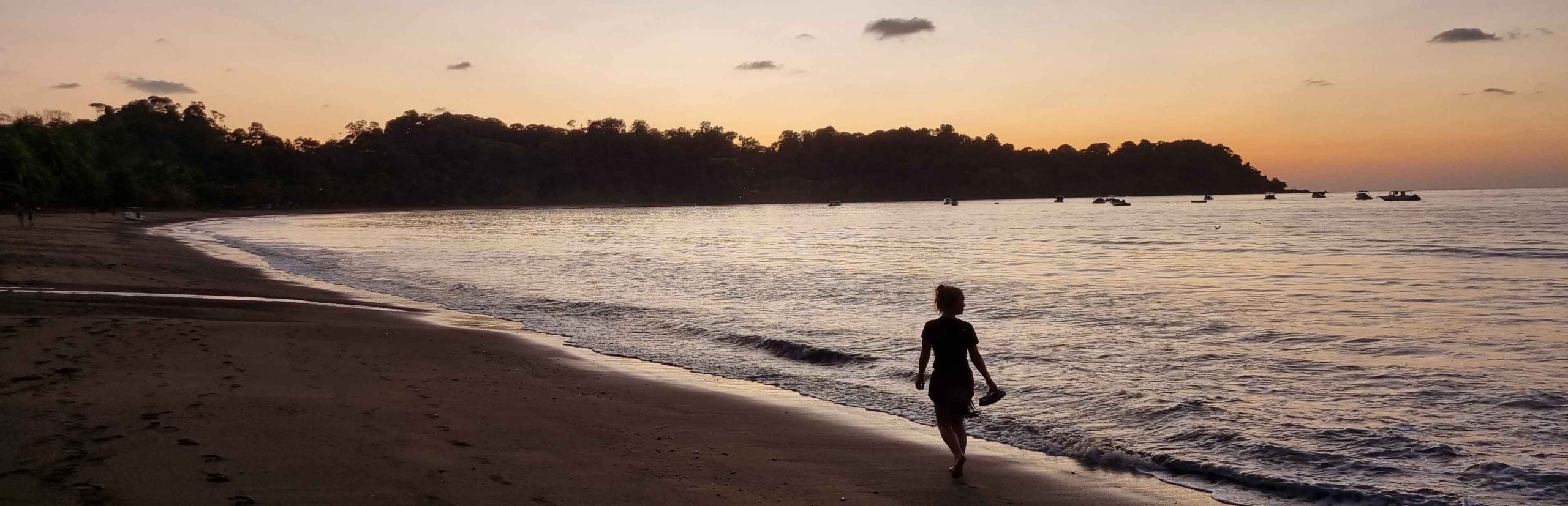 Vrouw op het strand bij zonsondergang in Costa Rica