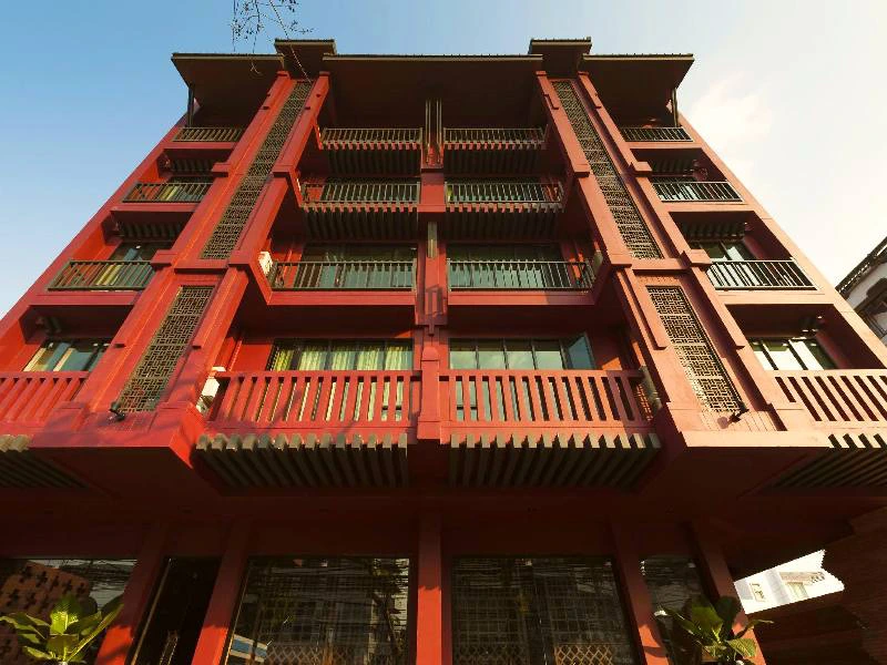 Straatperspectief omhoog gericht op een traditioneel hotel met rode en zwarte details in het houten gevelwerk