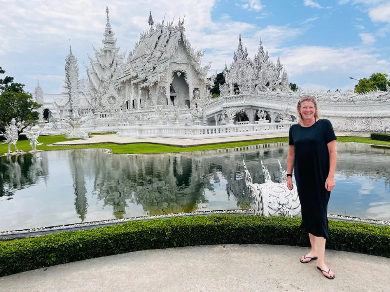 Vrouw die geposeert op de foto staat bij de White Temple in Chiang Rai in Thailand
