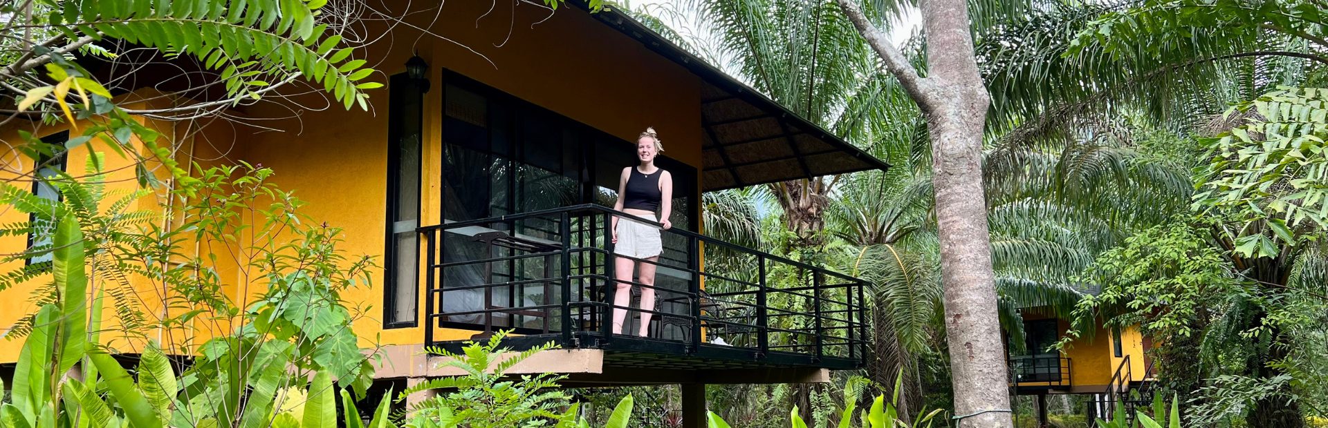 Vrouw die poseert voor de foto op de veranda van een eco-lodge in Khao Sok in Thailand