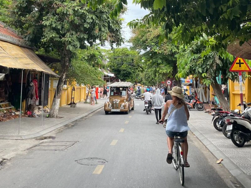Reiziger fietst door de straten van Hoi An.