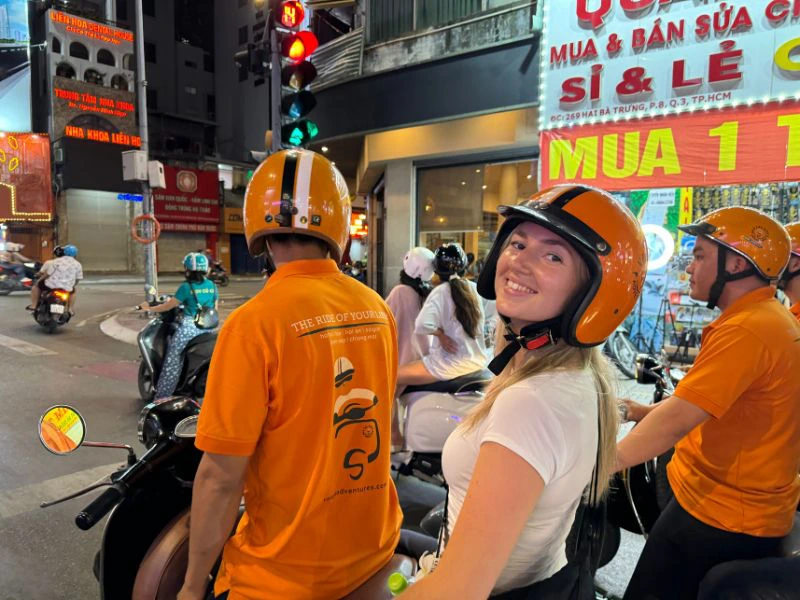 Een reiziger achterop de scootertaxi in het drukke Ho Chi Minh City