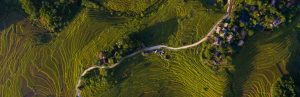 Bovenaanzicht van groene rijstterrassen en lokale dorpjes.