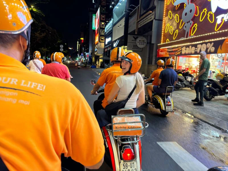 Jonge reiziger zit achterop bij de scootertaxi.