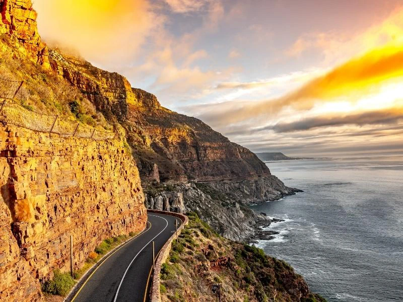 Autoweg aan het water naast bergen in Zuid-Afrika
