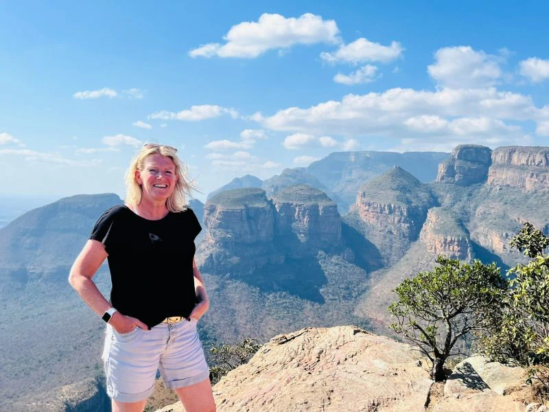 Vrouw poseert bij uitzicht punt op de panoramaroute