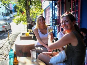 Vrouwen zitten op een terras en proosten met een wijntje
