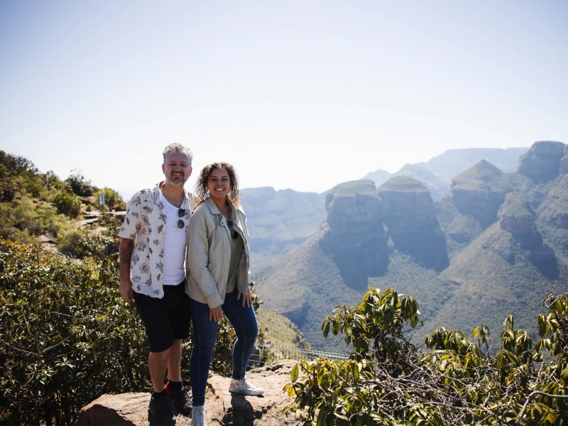 Twee mensen staan op een klif met uitzicht op bergen in Zuid-Afrika