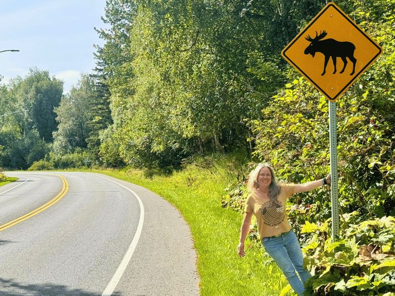 vrouw met eland bord langs de weg