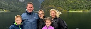 Familie staat voor een fjord in Noorwegen.