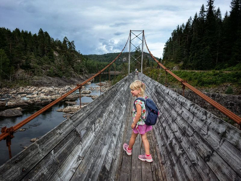 Meisje wandelt over een houten brug in Noorwegen.
