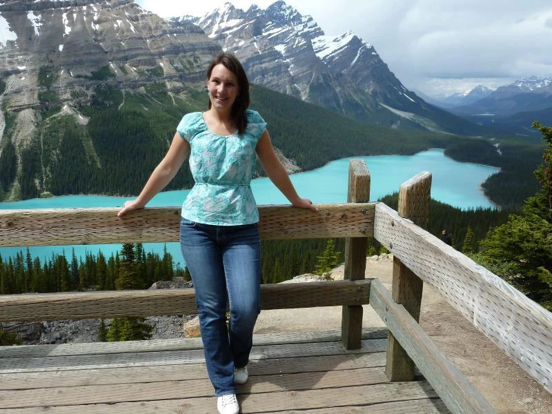 Vrouw poseert voor helderblauw Lake Peytoo