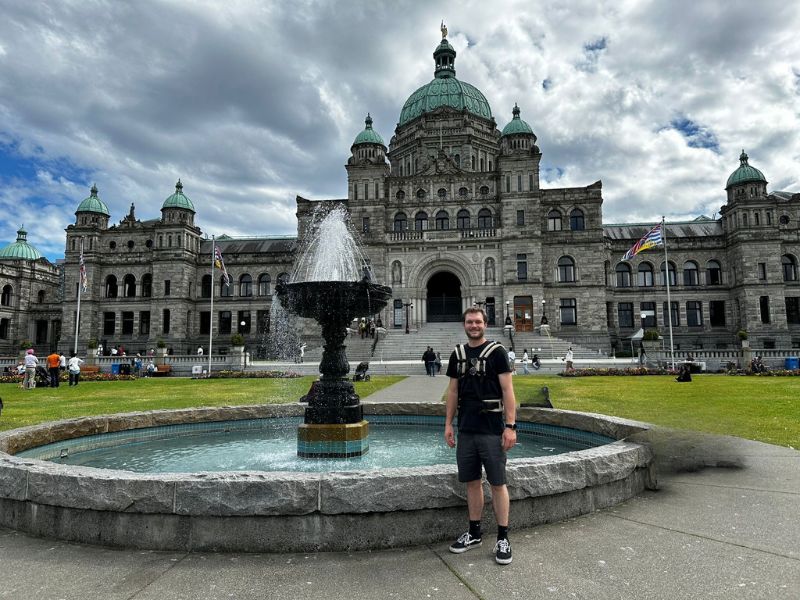 man poseert voor parlament huis Victoria