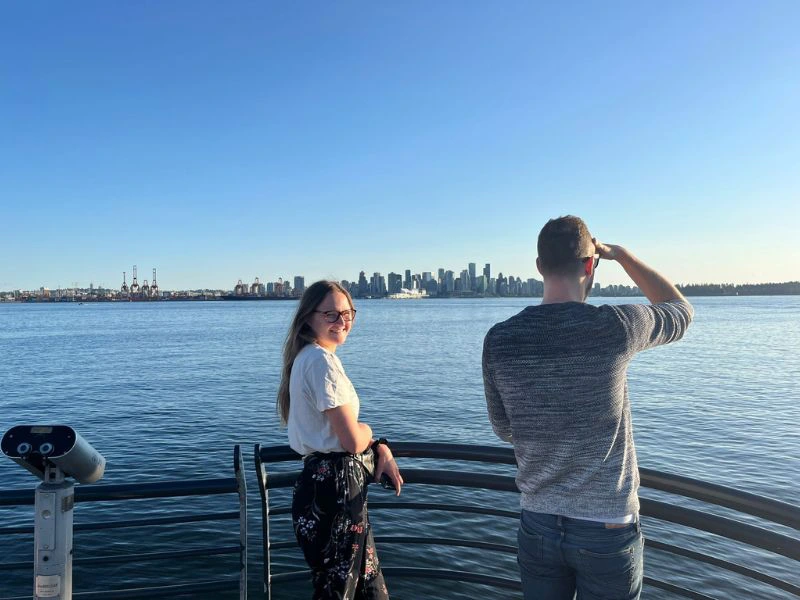 Reizigers kijken over het water naar downtown Vancouver.