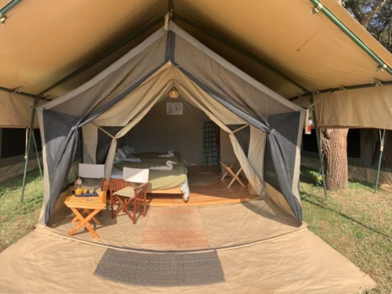 Voorkant van tent met bedden en een terrasje