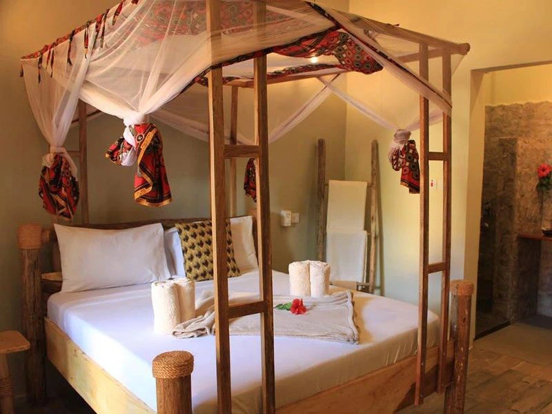 hotel kamer in lodge moshi met een mooi houten bed