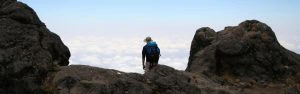Man staat op de Kilimanjaro boven het wolkendek.