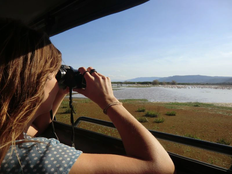 Reiziger kijkt met verrekijker naar vogels in Lake Manyari.