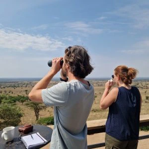 Reizigers genieten van het uitzicht over het Serengeti van hun terras.